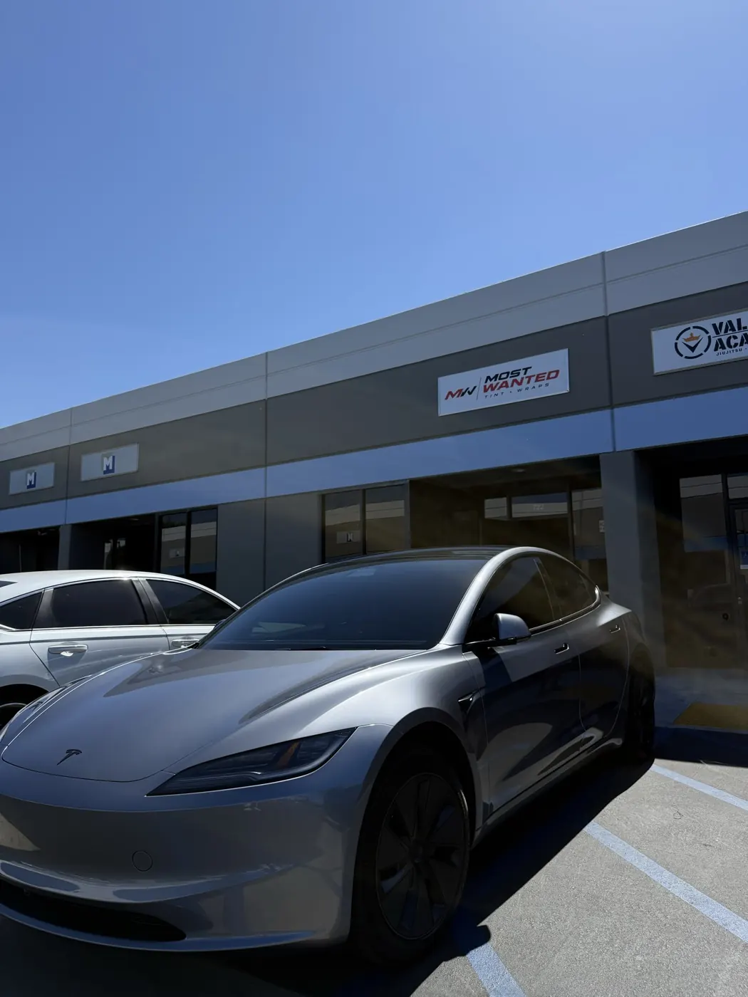 Silver Tesla Model 3 with fresh ceramic tint outside the shop