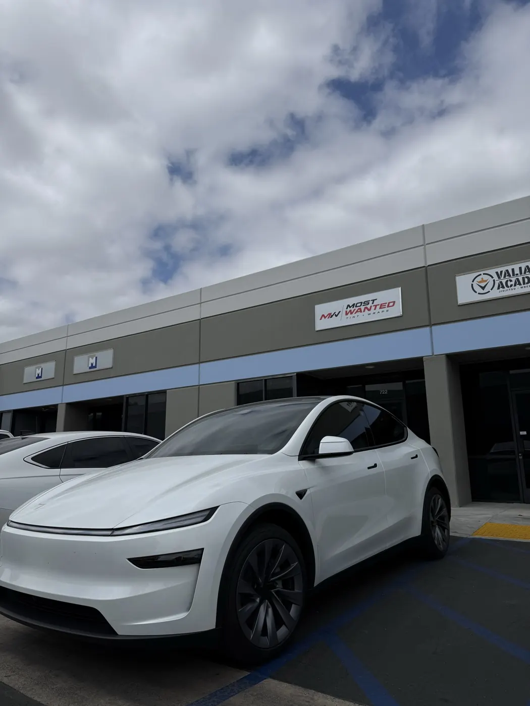White Tesla Model Y with tinted windows at the shop