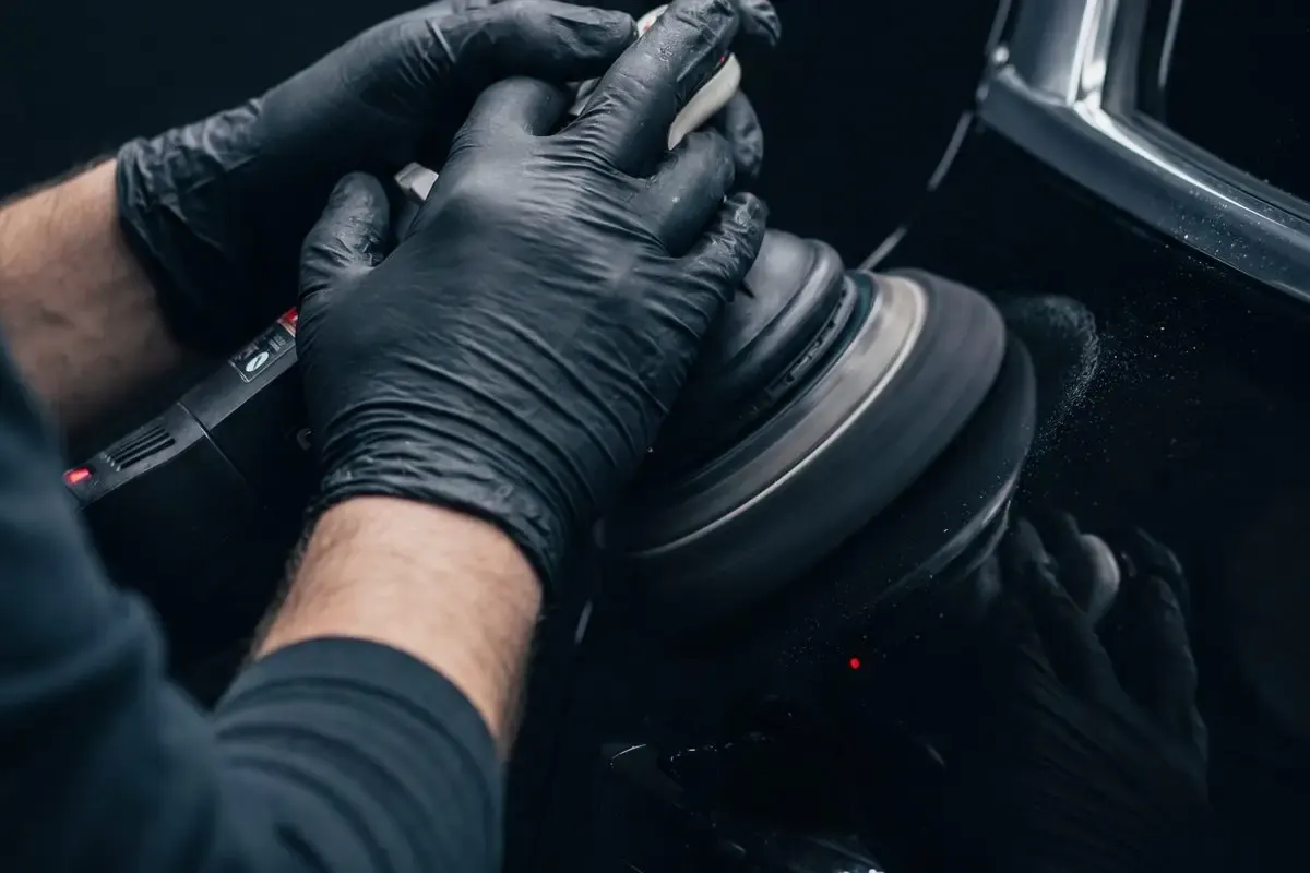 Machine polishing a panel before ceramic coating in the Most Wanted studio